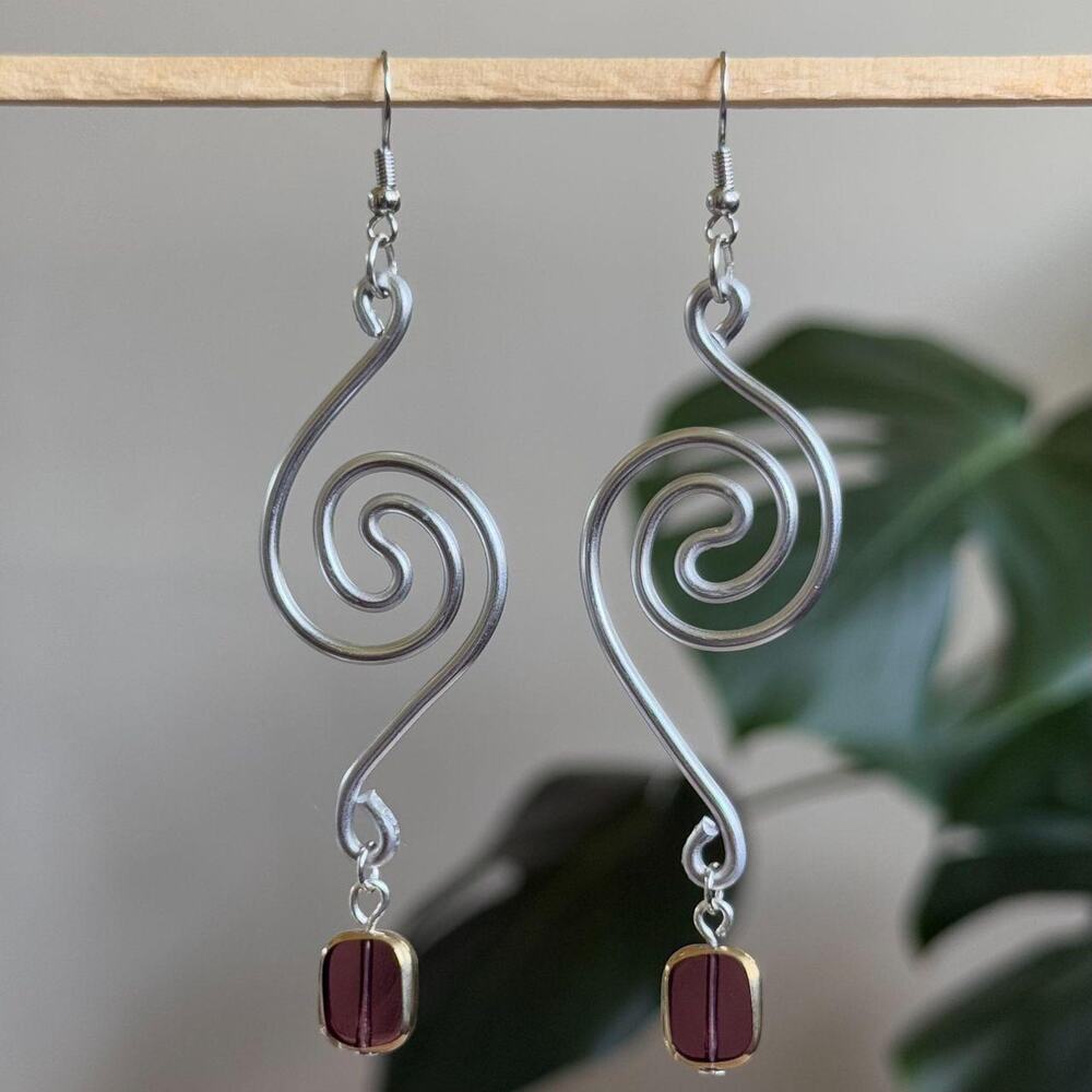 handmade silver wire whirlpool spiral earrings with dangling purple glass beads